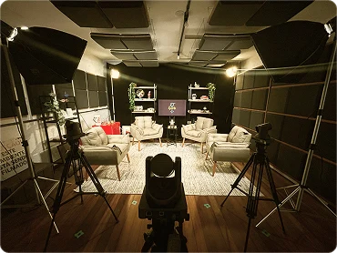 Estúdio com cadeiras, iluminação e câmera profissional