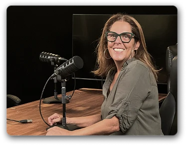 Vanessa olhando para a câmera em mesa de podcast